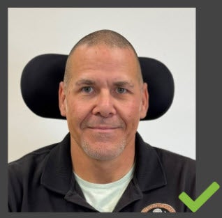 The customer is sitting in a wheelchair, and part of the wheelchair's head support is in the image.